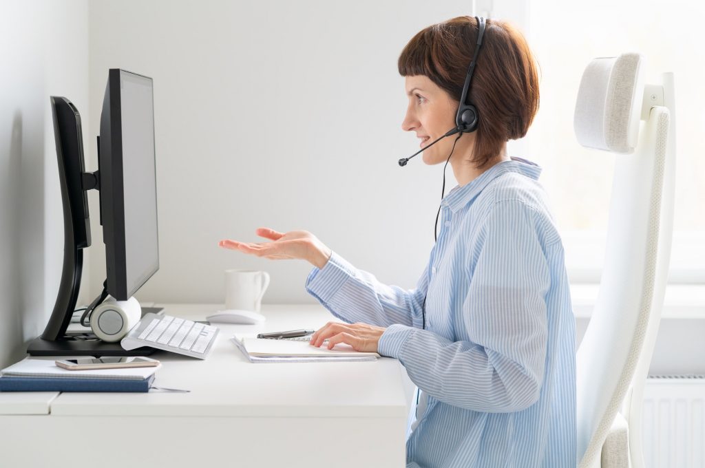Mature smiling woman talking at video conference, online presentation, workshop